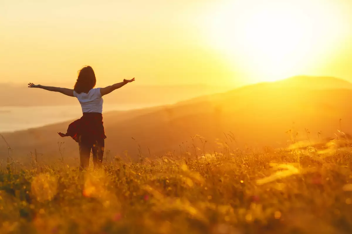 Woman stretching and looking at sunset